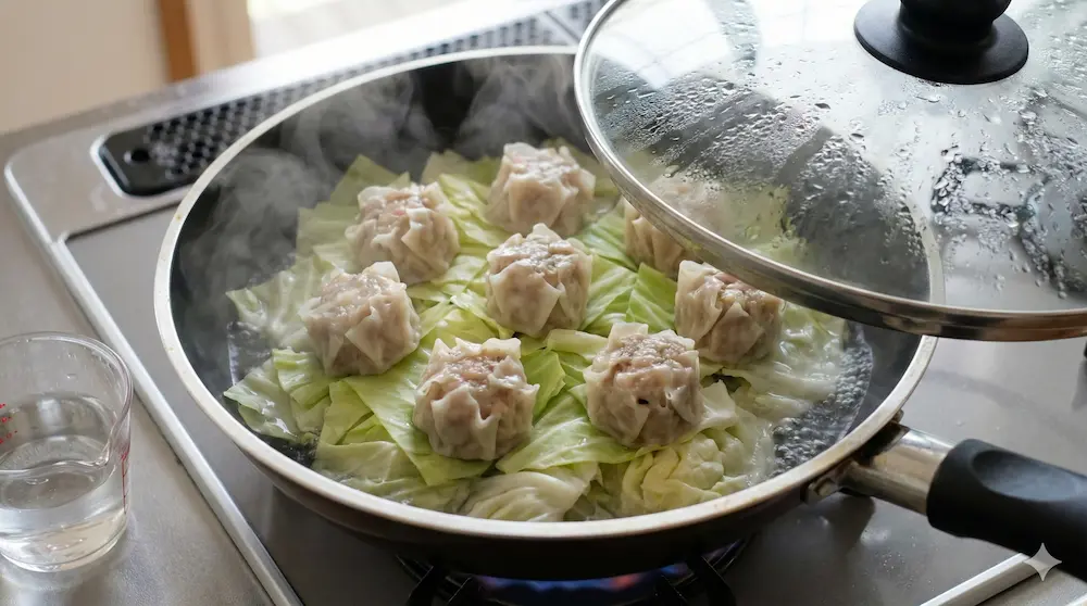 フライパンに野菜を敷いて焼売をふっくら蒸し焼きにするイメージ画像